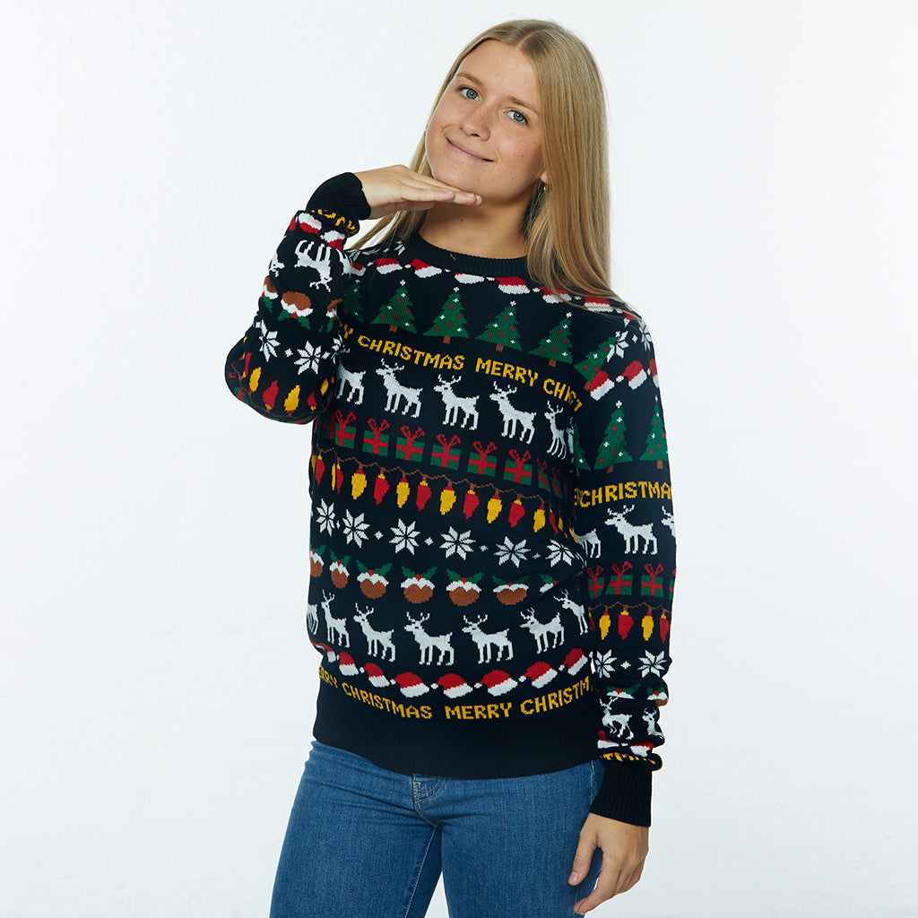 En poserende dame iført en sort julesweater med rensdyr, juletræer og julepynt.